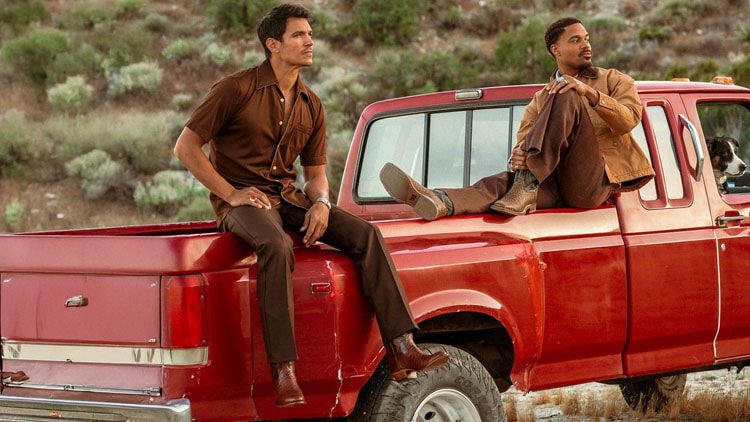 Two men wearing Signature Series boots sitting on a red truck.